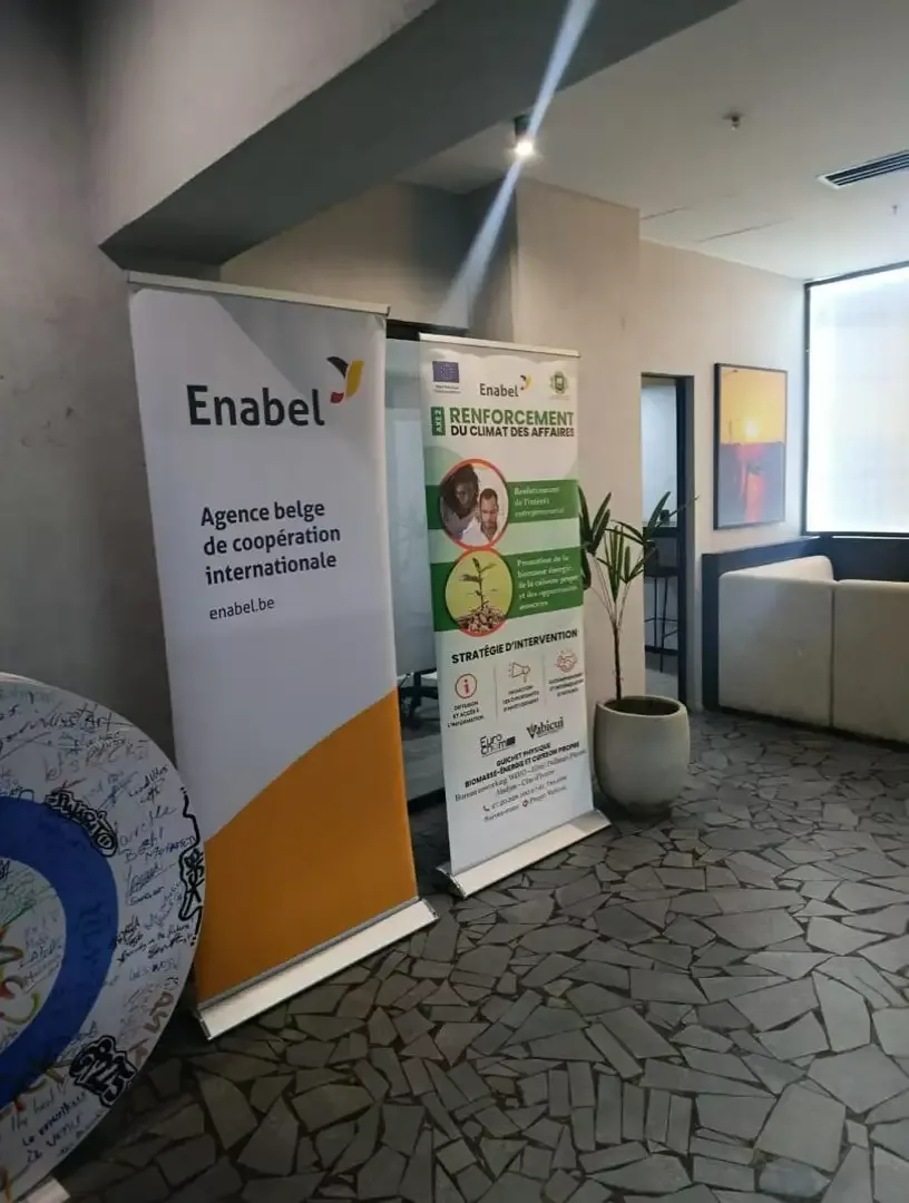 Vabicui — Deux bannières verticales posées au sol dans un bureau. La première affiche le logo Enabel avec la mention 'Agence belge de coopération inte