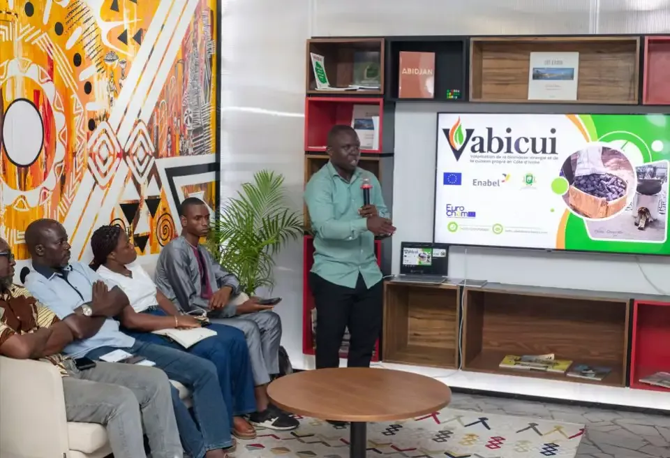 Vabicui — Un homme debout présente un projet nommé Vabicui sur un écran géant dans une salle moderne, entouré de quatre personnes assises attentives,